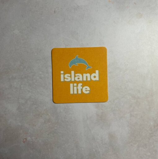 island life key west lager logo with blue dolphin on yellow coaster